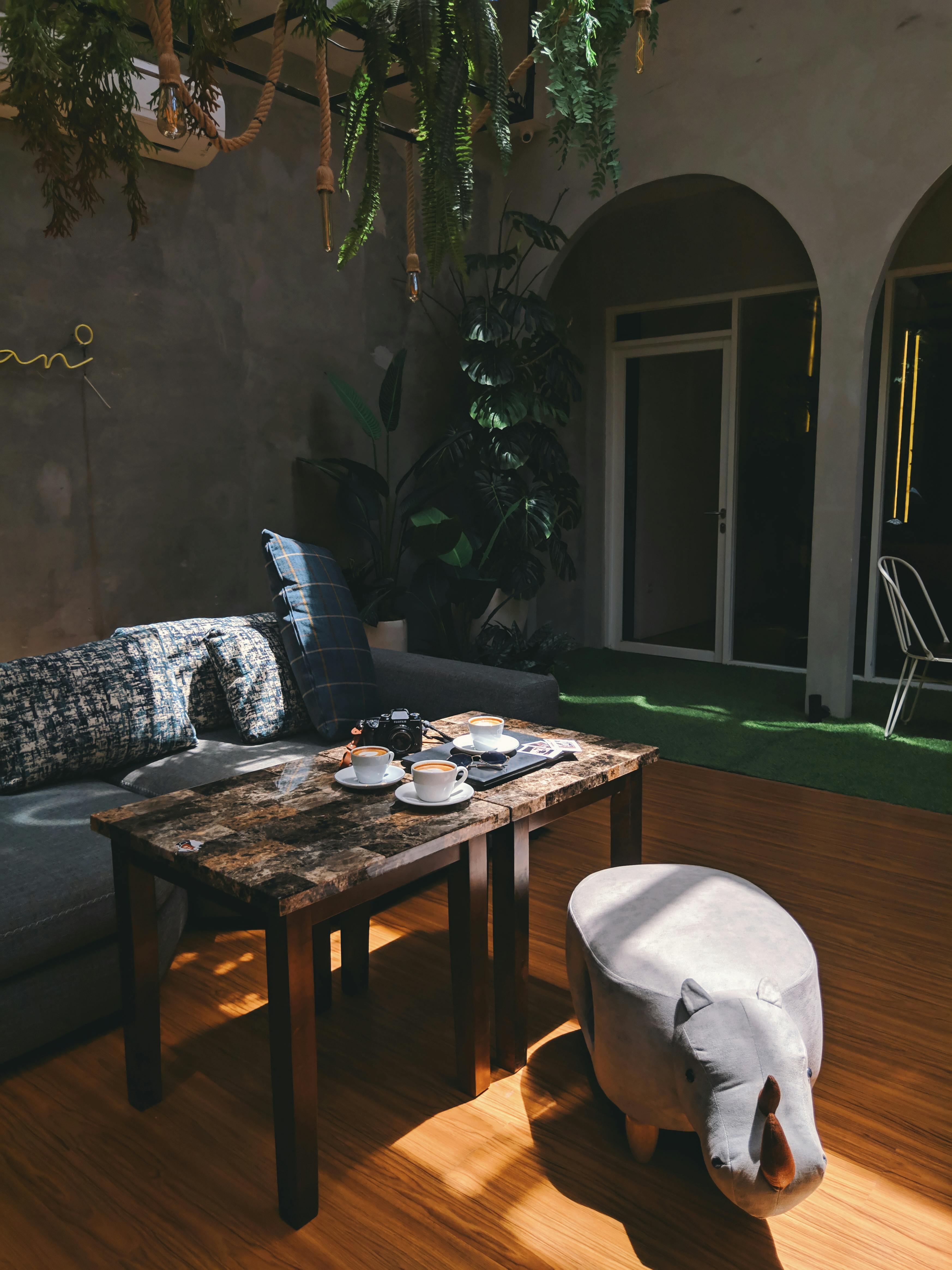 Editorial living room scene with a rustic coffee table set with teacups, textures, and natural light.